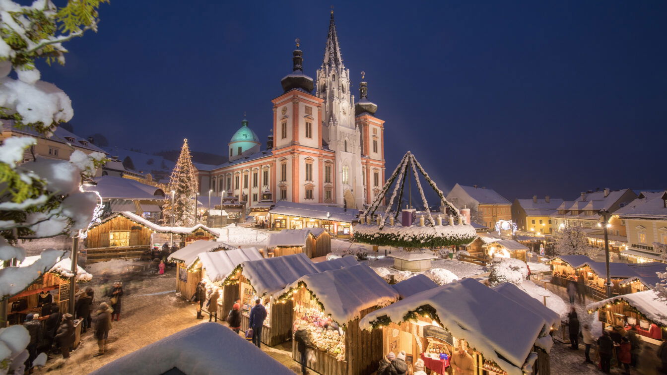 Ein schneebedeckter Platz mit Lichtern vor einer Kirche