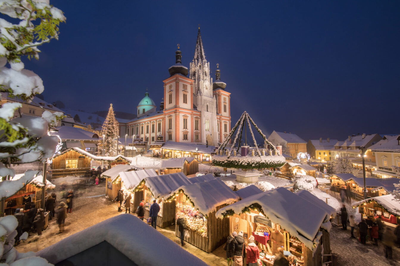 Ein schneebedeckter Platz mit Lichtern vor einer Kirche