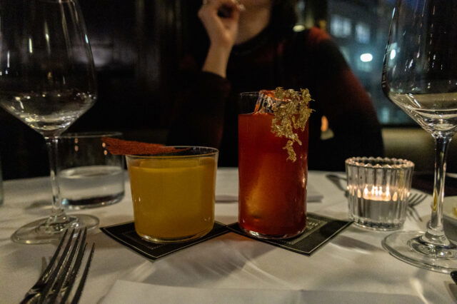 Zwei kunstvoll dekorierte Cocktails auf elegant gedecktem Tisch in einem der Restaurants Zürich außergewöhnlich – stilvolles Fine-Dining-Ambiente mit gedimmtem Licht und moderner Barkultur.