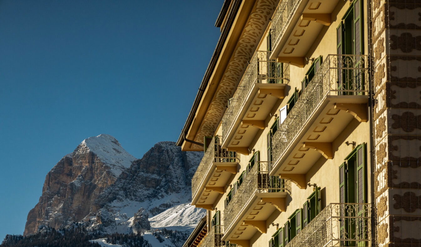 Eine Hotelfassade vor einem Bergpanorama in Cortina