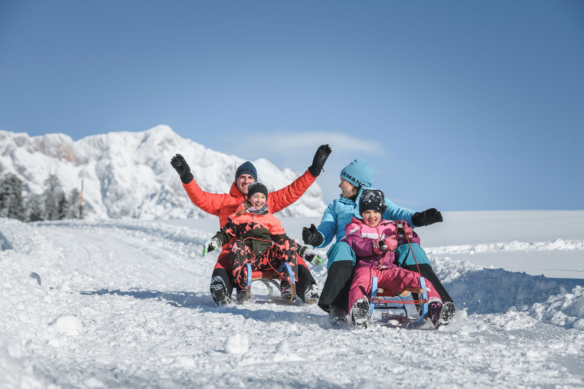 Familie fährt Schlitten im Schnee (c) Hochkönig Tourismus GmbH