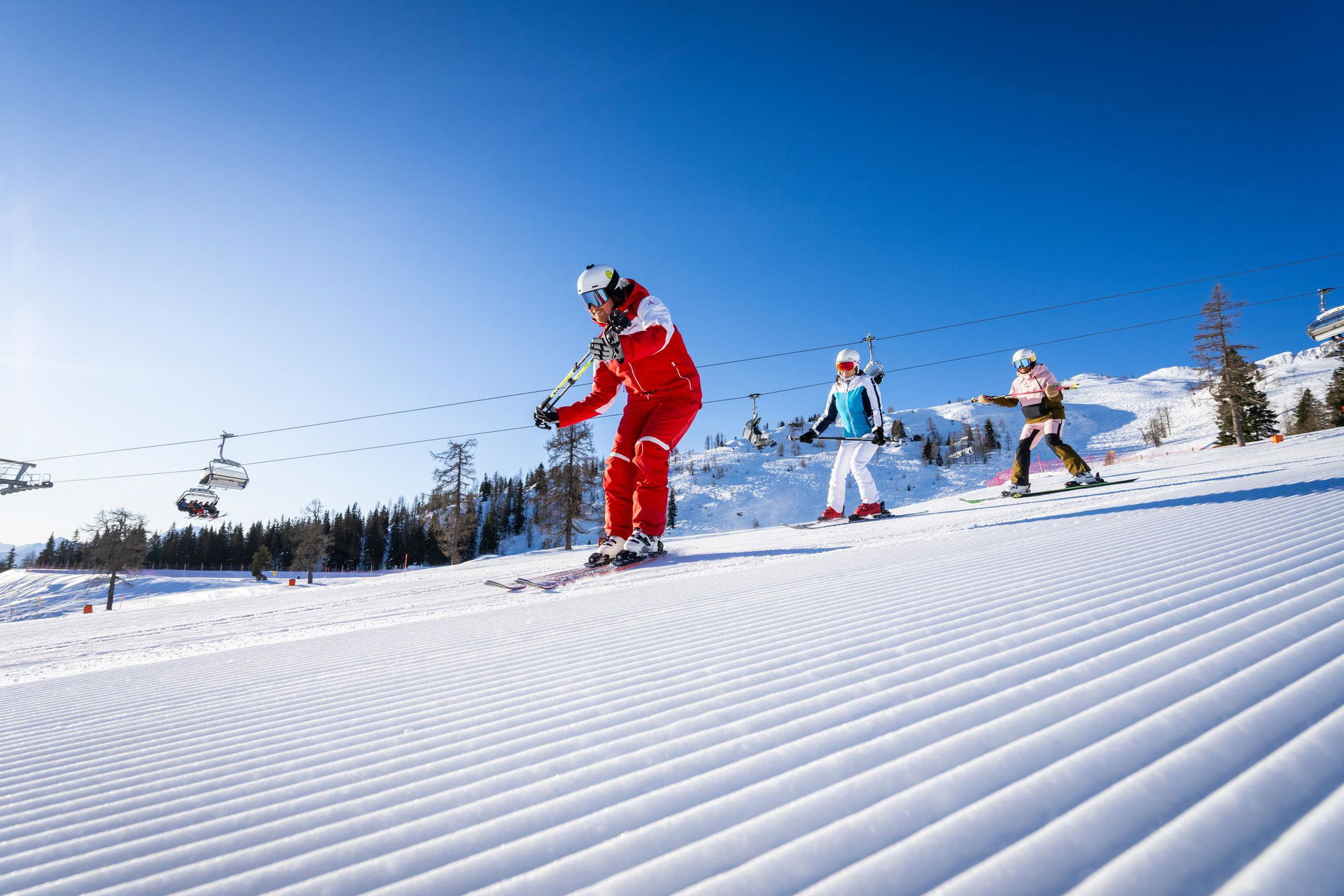 Skifahrende auf der Piste bei Sonnenschein