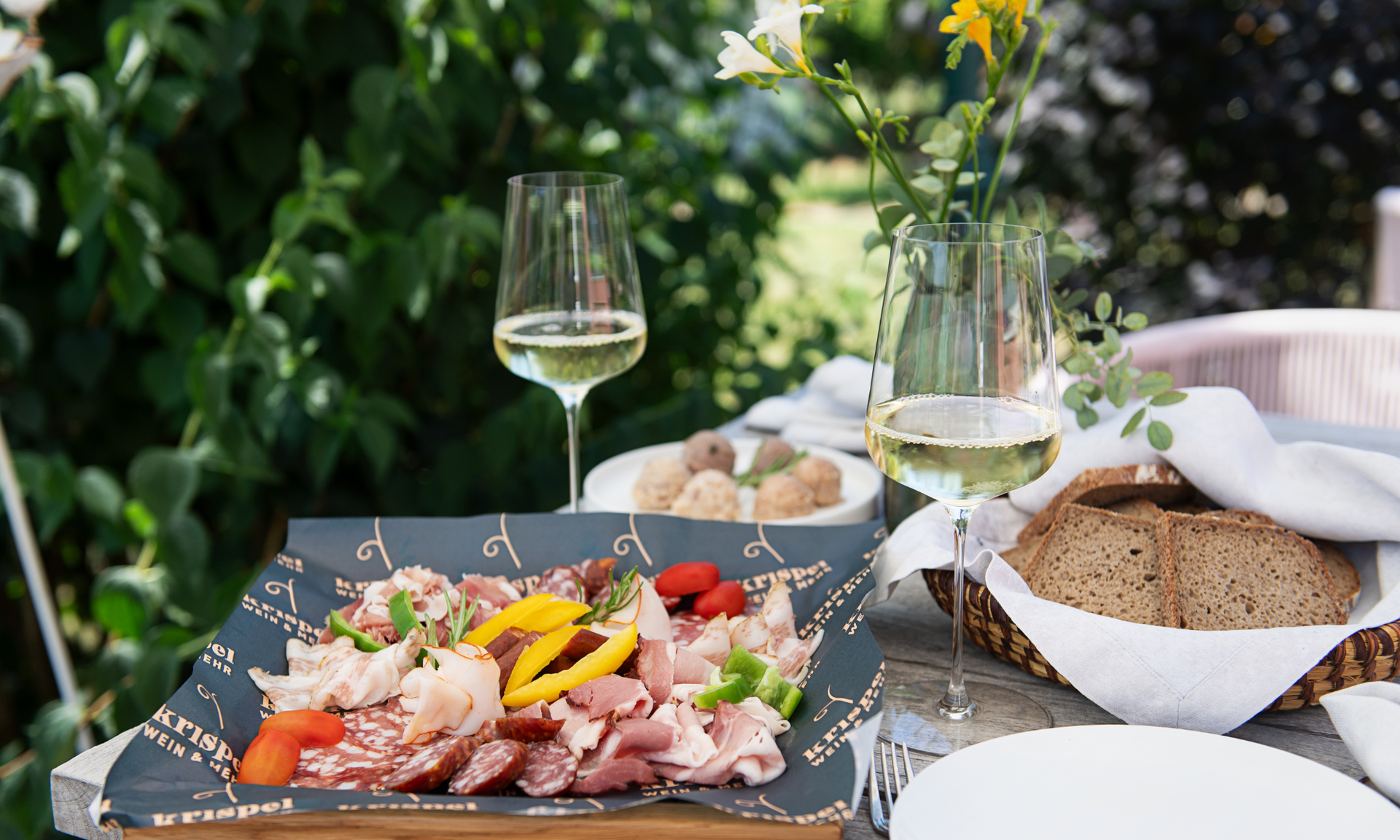 Snackplatte mit Fleisch und Gemüse, Brot und Wein