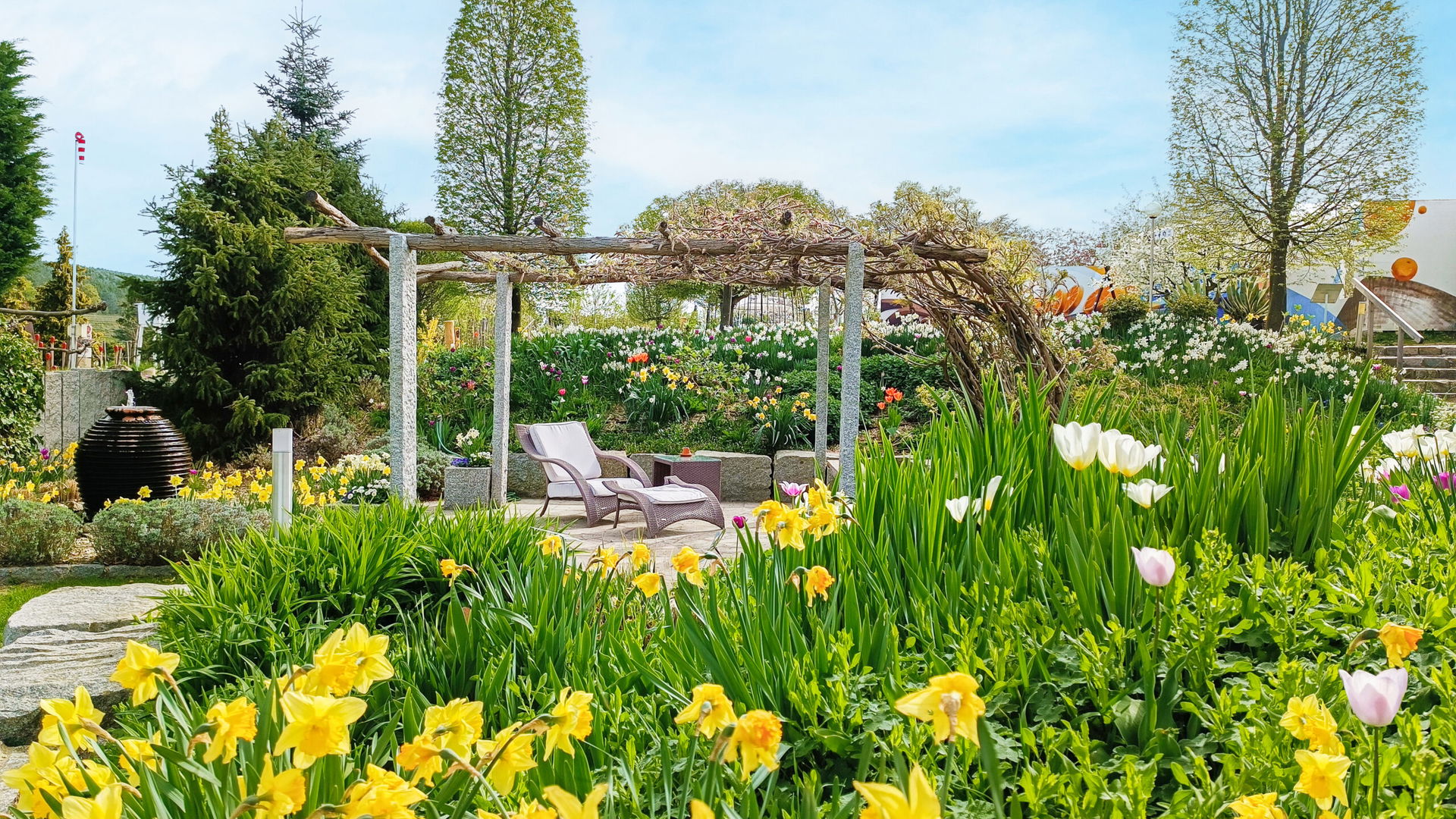 Blick auf einen blühenden Garten mit Liegestuhl