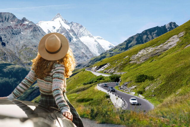 Frau mit Hut lehnt an einem Auto und schaut auf die Großglockner Hochalpenstraße