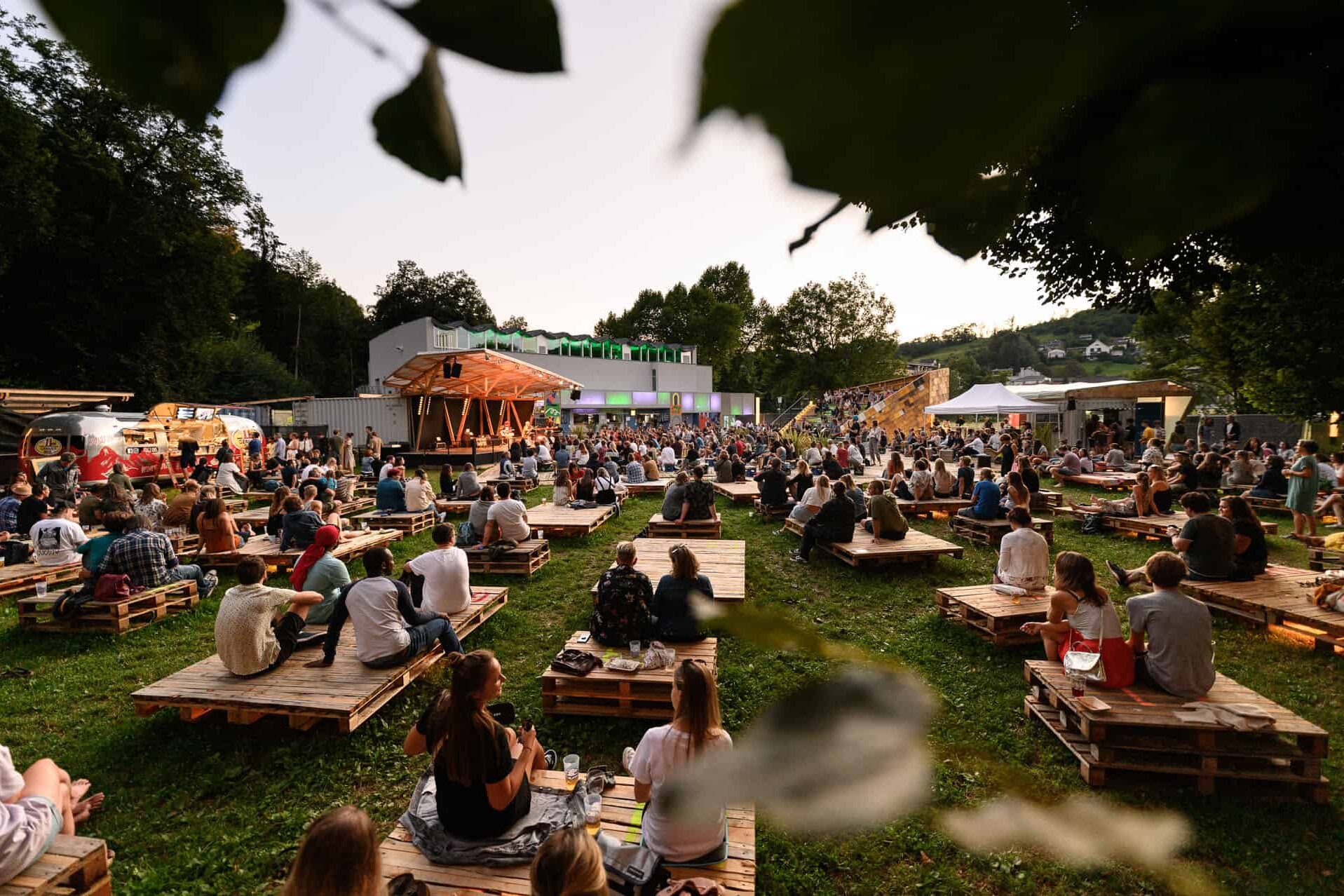 Festival in Österreich im Grünen, Menschen vor einer Bühne im Grünen