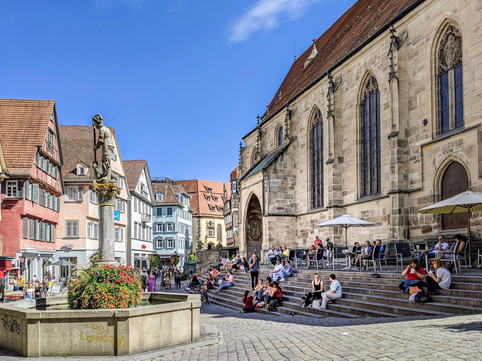 Der Georgsbrunnen mit dem Heiligen Georg und die Stiftskirche St. Georg am Holzmarkt in Tübingen.