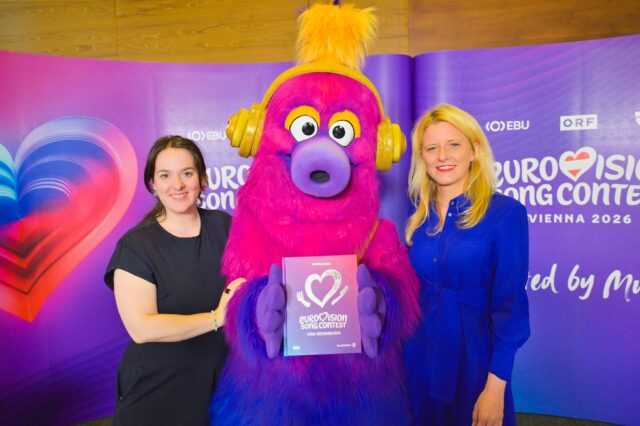 Eurovision Song Contest Kochbuch: Zum ESC in Wien 2026 bringen Brandstätter und ORF ein Buch mit Rezepten aus allen Teilnehmerländer heraus. Im Bild u.a.: Manuela Tiefnig (Autorin) und ESC-Maskottchen Auri.