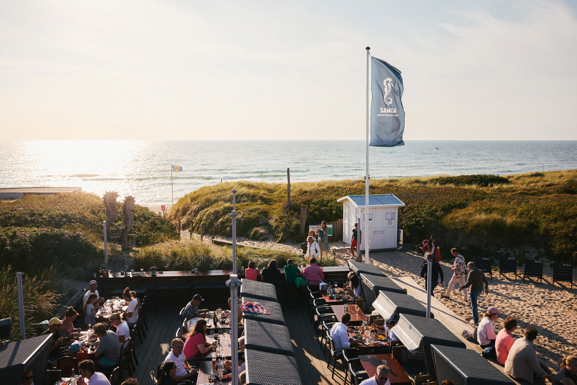 Strandbistro auf Sylt mit Personen bei Sonnenuntergang