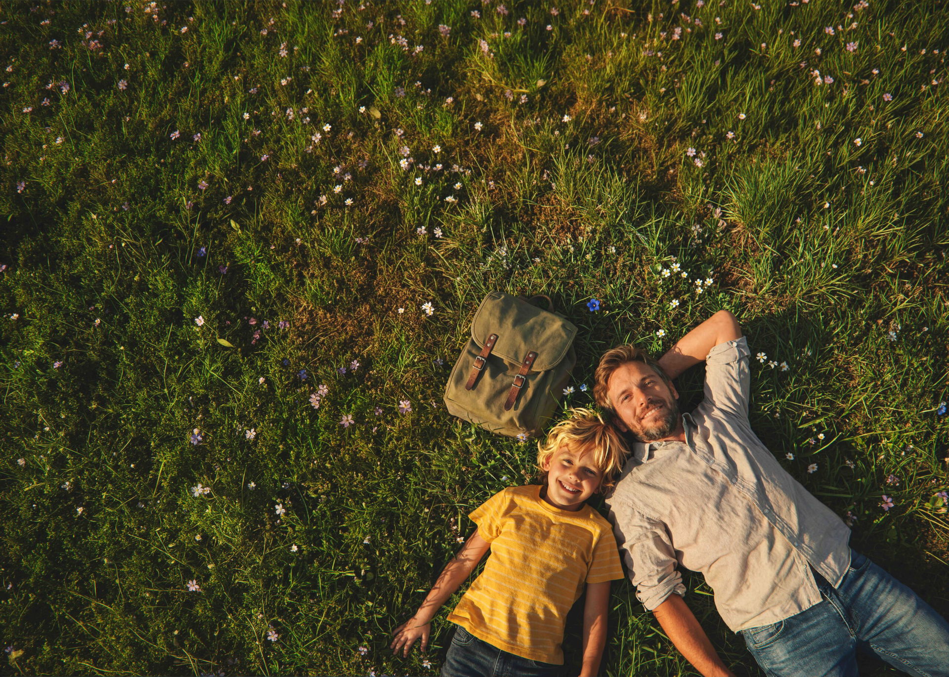 Mann und Kind liegen im Gras