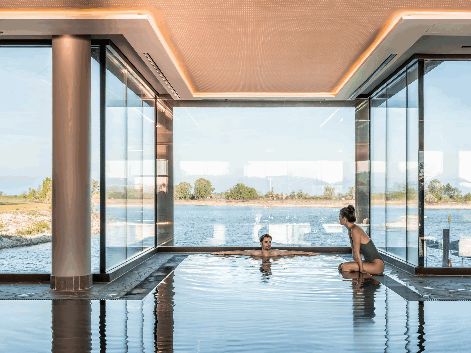 Zwei Personen sind im Pool vom See-Spa der St. Martins Therme & Lodge 