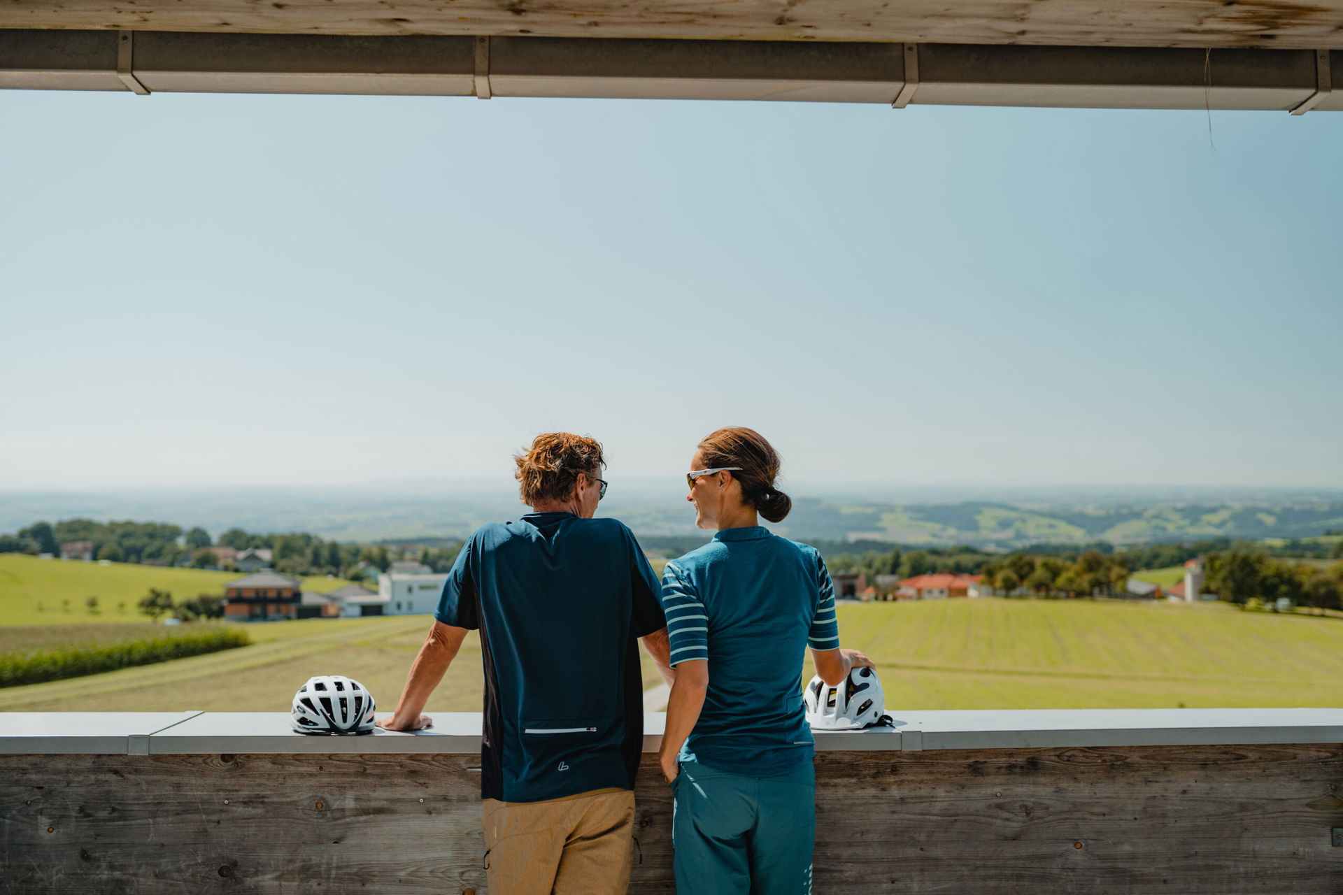 Zwei Personen von hinten, es sind Radfahrer an der Pyramide Etzinger Hügel auf der Radtour Sauwald Panoramastraße. Toller Ausblick. © CM Visuals