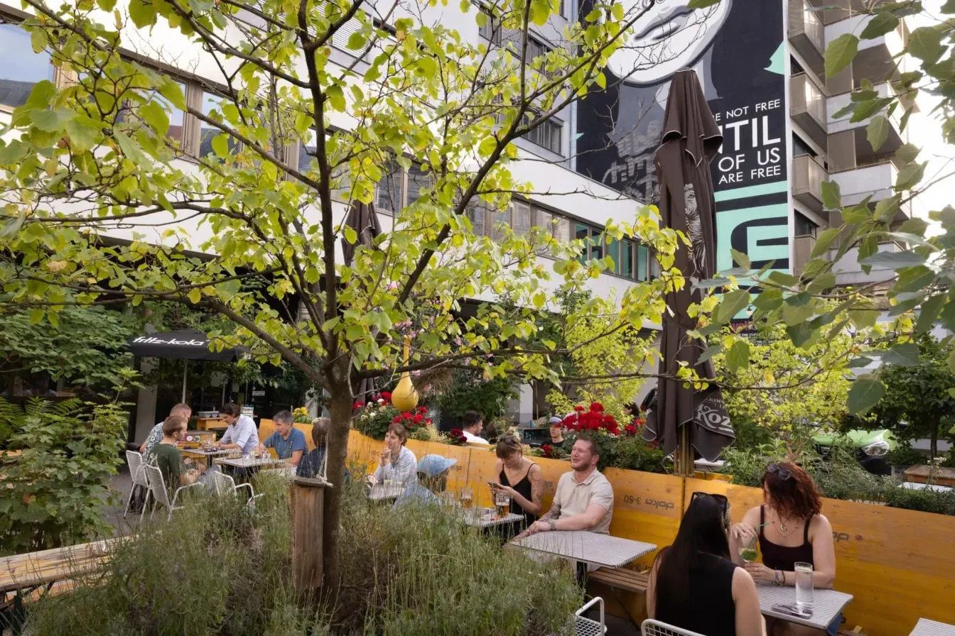 Menschen sitzen im Gastgarten des Lokals WerkzeugH in Wien