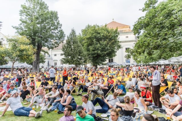Menschen sitzen im Garten des Palais Auersperg im 8. Bezirk in Wien und verfolgen die Fußball-WM beim Public Viewing