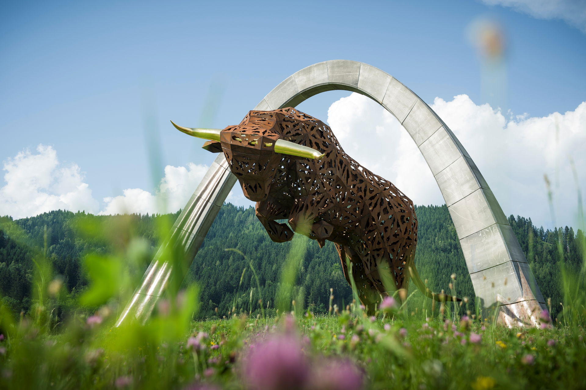 Der Bulle am Red Bull Ring in Spielberg im Murtal mit frühlingshaften Blumen im Vordergrund
