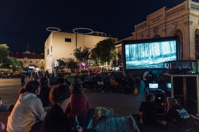 Menschen sitzen bei einer Open-Air-Kinovorstellung im MuseumsQuartier in Wien