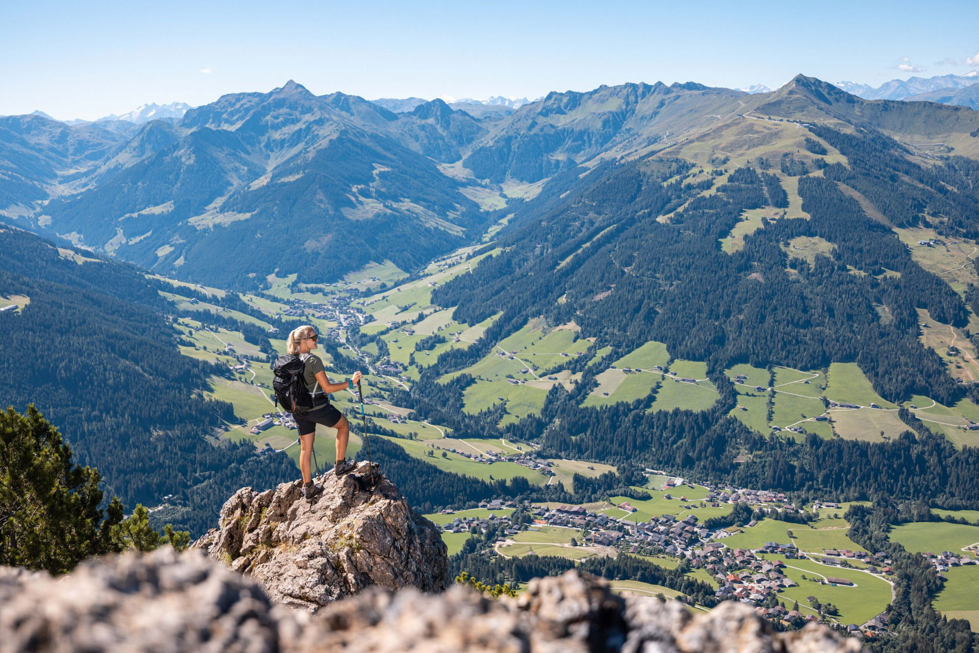 Frau schaut vom Gipfel der Gratlspitze im Alpbachtal ins Tal