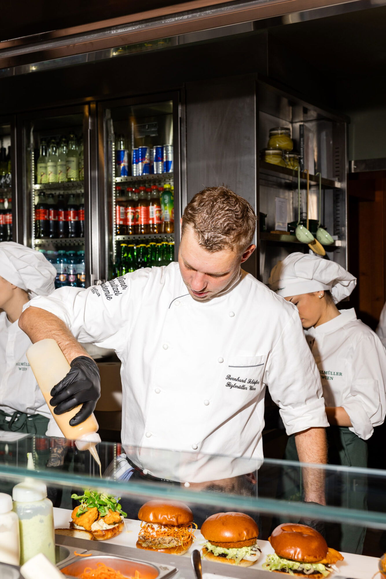 Köche bereiten im Restaurant Brioche und Brösel in Wien Burger zu