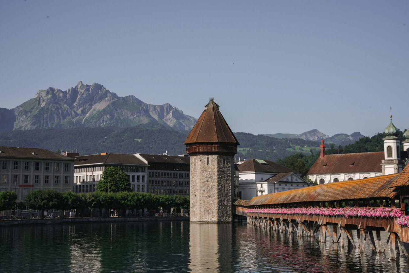 Die Kapellbrücke in Luzern mit dem Fluss Reuss und dem Bergpanorama im Hintergrund.
