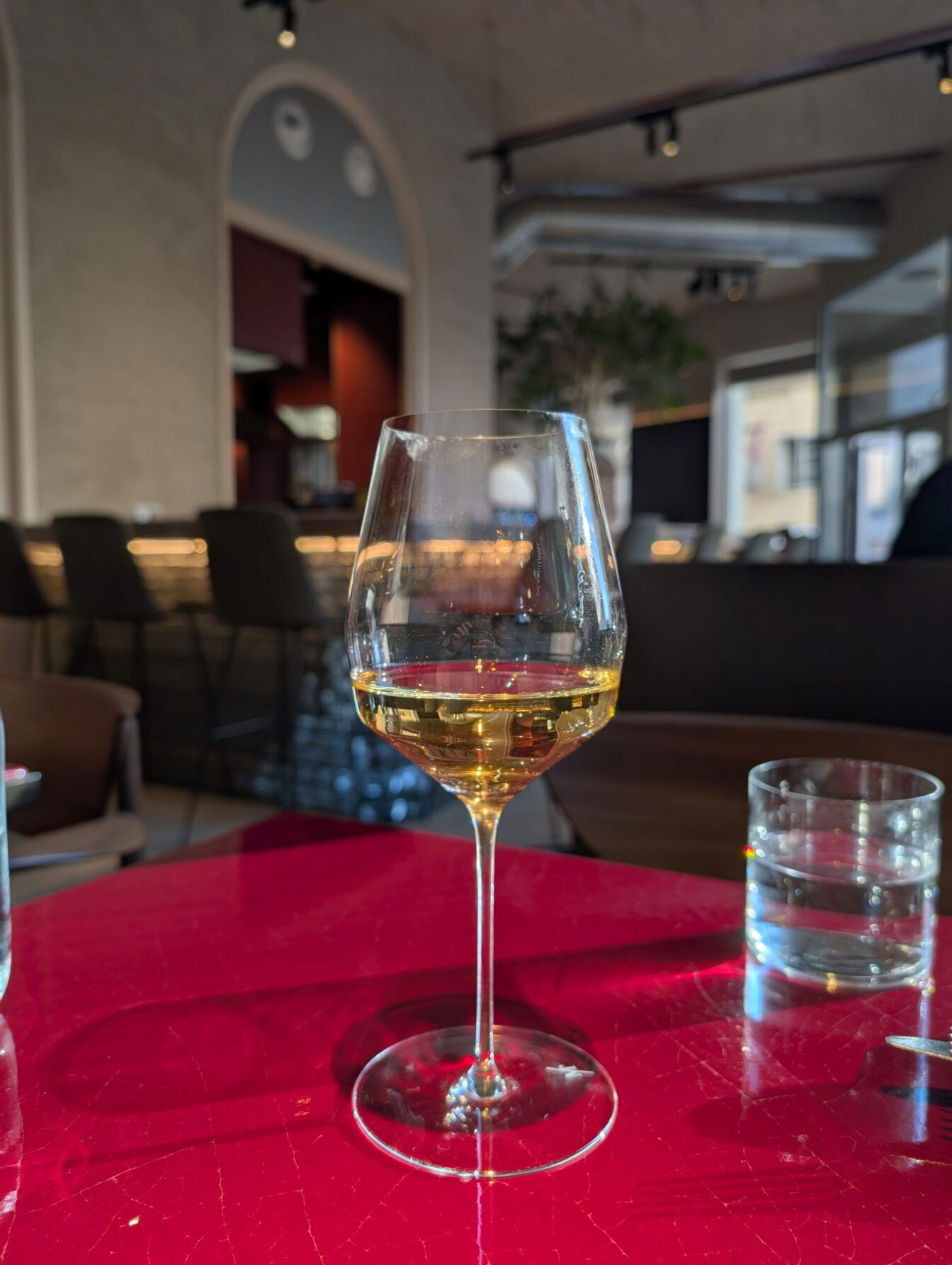 ein Glas Wein steht auf einem Tisch im Restaurant Lara in Wien