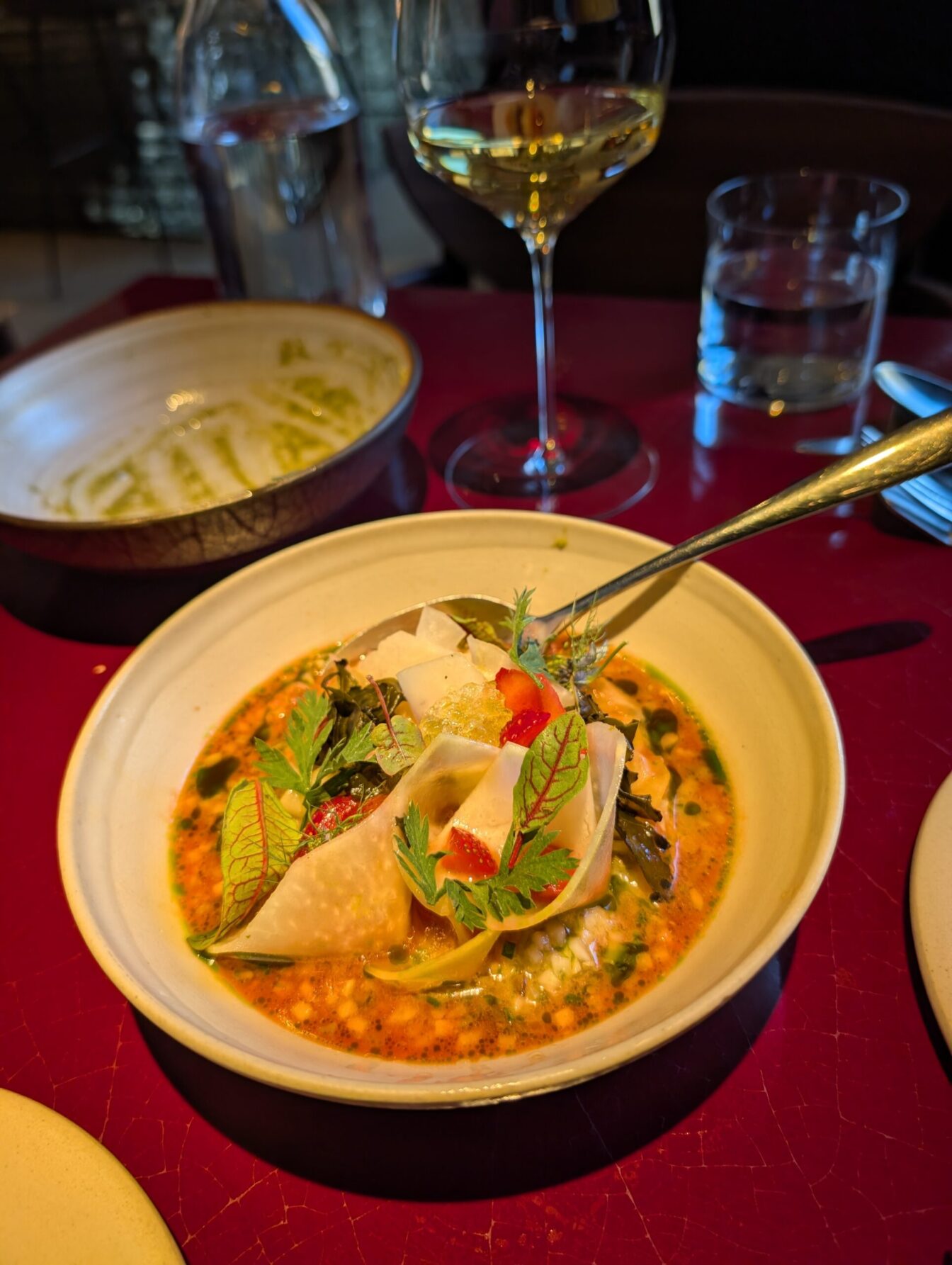 im Vordergrund steht ein Gericht, im Hintergrund ein Glas Wein auf einem Tisch im Restaurant Lara in Wien