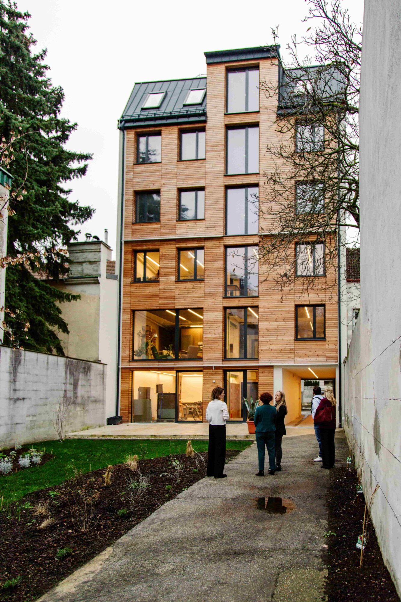 Blick auf die Fassade des Roots House inklusive Grünfläche davor