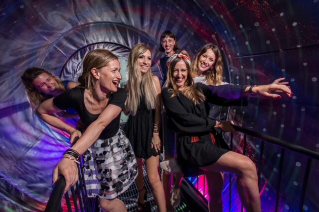 eine Gruppe von Frauen steht in einer Attraktion im Museum der Illusionen in Wien