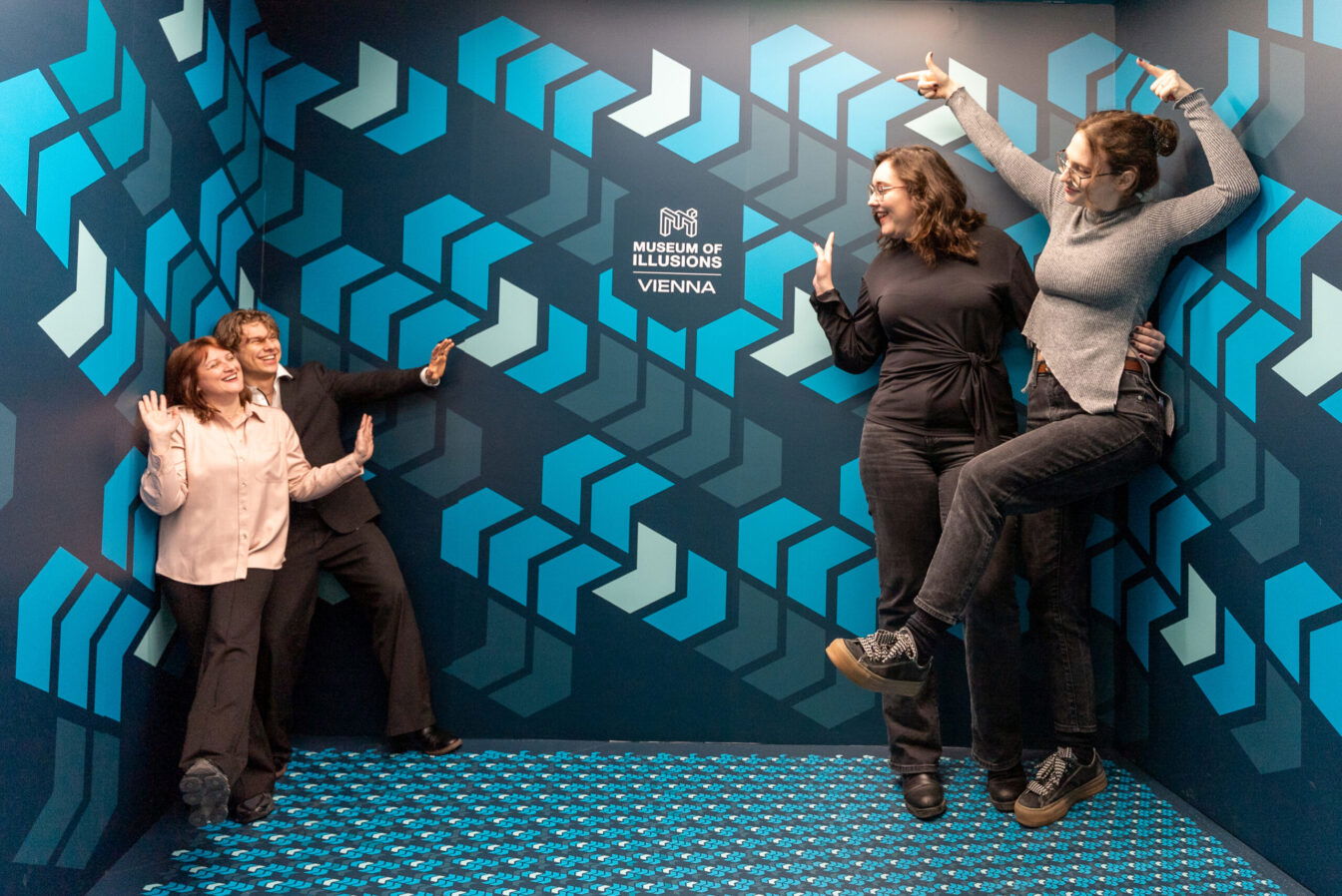 eine Freundesgruppe steht in einer Attraktion im Museum der Illusionen in Wien