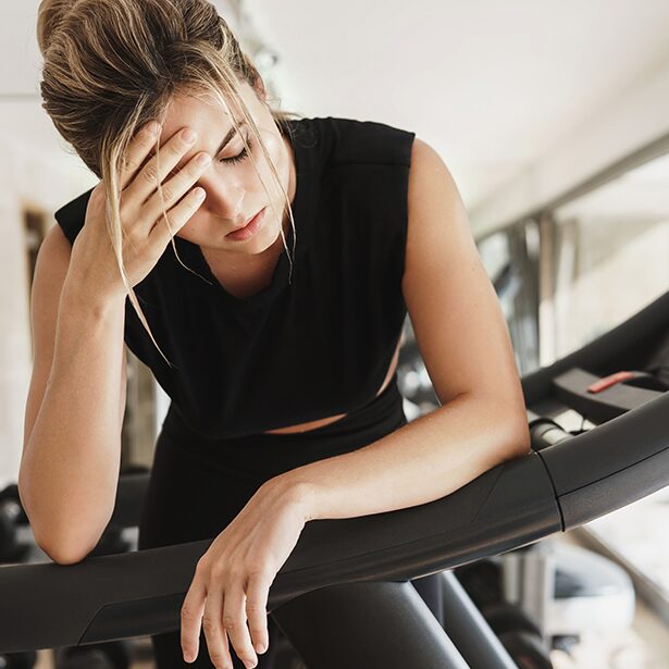Erschöpfte junge Frau auf dem Laufband.