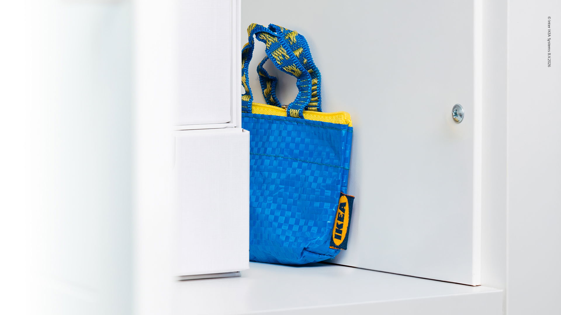IKEA Frakta Tasche versteckt zwischen weißen Möbeln
