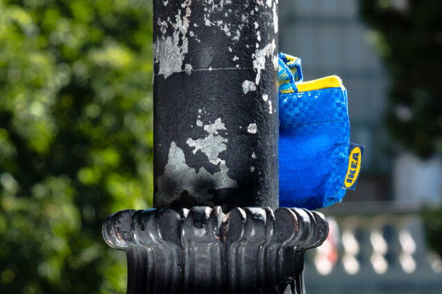 IKEA Frakta Tasche versteckt sich hinter einer Straßenlaterne