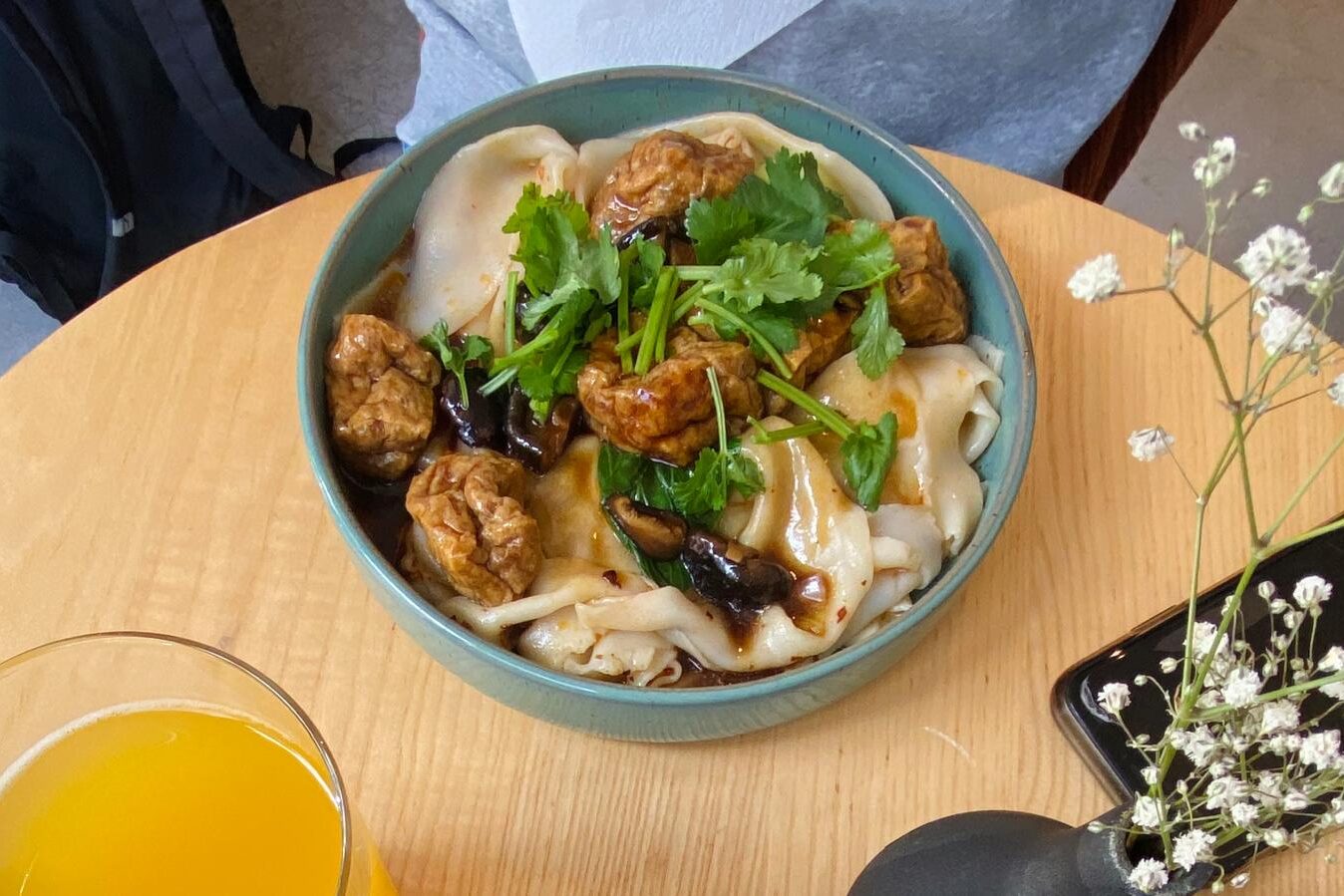 Eine Schale mit einem asiatischen Nudelgericht auf einem kleinen Tisch im einem Restaurant