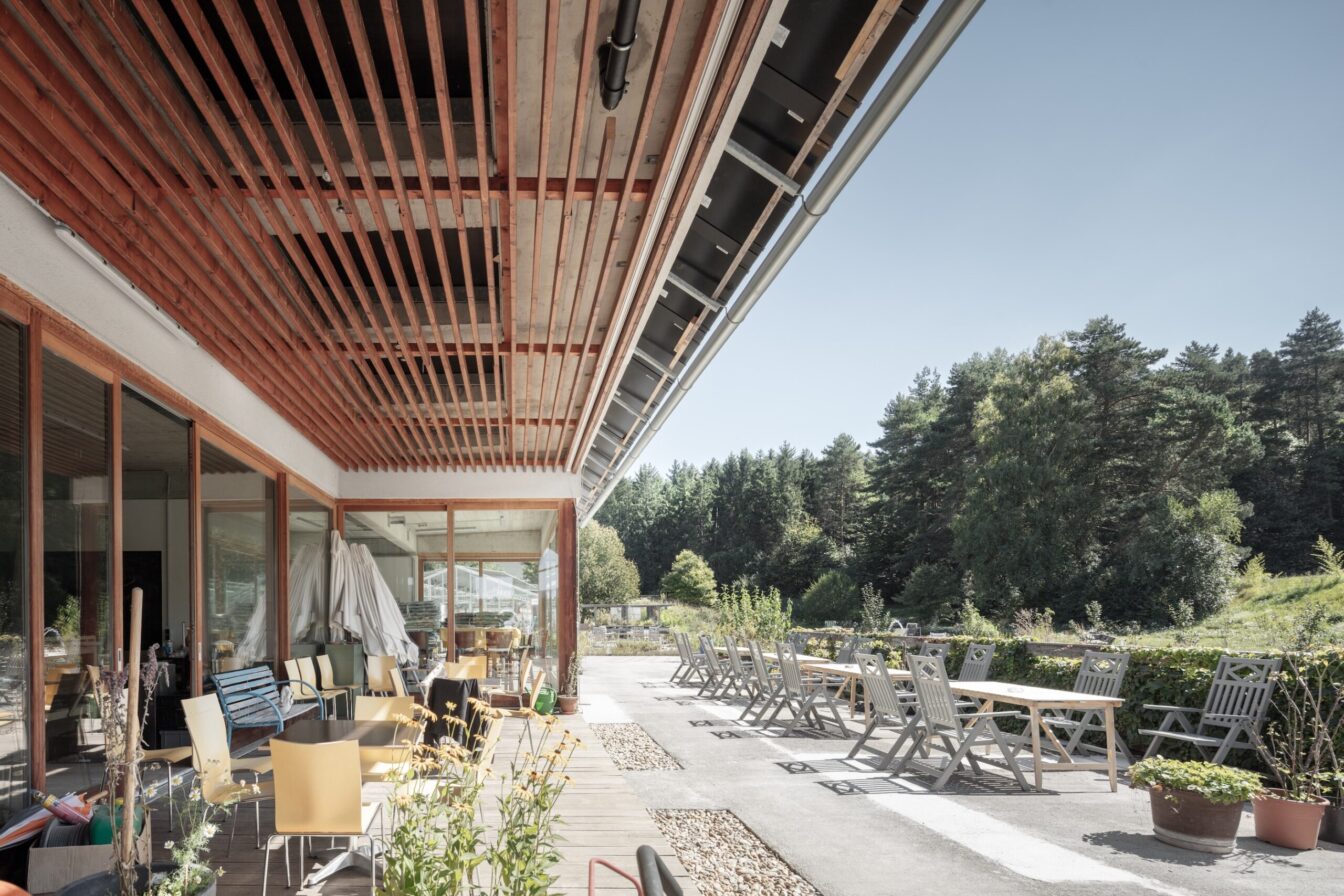 Terrasse mit Tischen, Sesseln, Bänken und Blick in die Natur bei VinziRast am Land in Mayerling in Niederösterreich