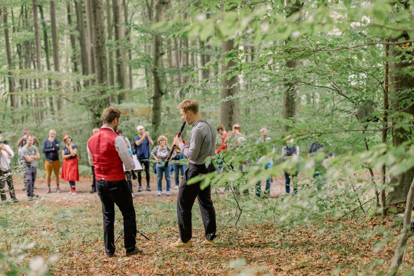 zwei Männer geben ein Konzert vor kleinem Publikum mitten im Wienerwald