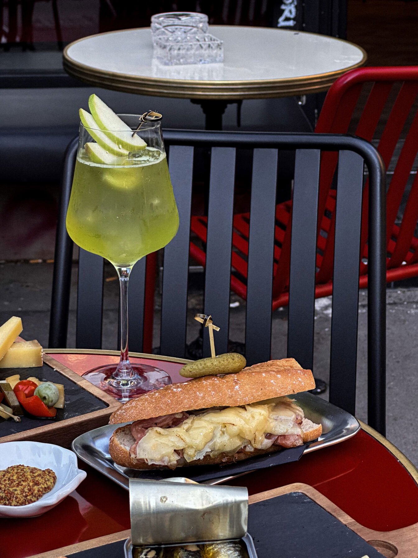 gedeckter Tisch mit grünem Cocktail und Charcuterie