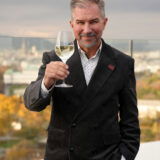 Porträtfoto von Journalist Bernhard Degen, der ein Glas Wein in der Hand hält