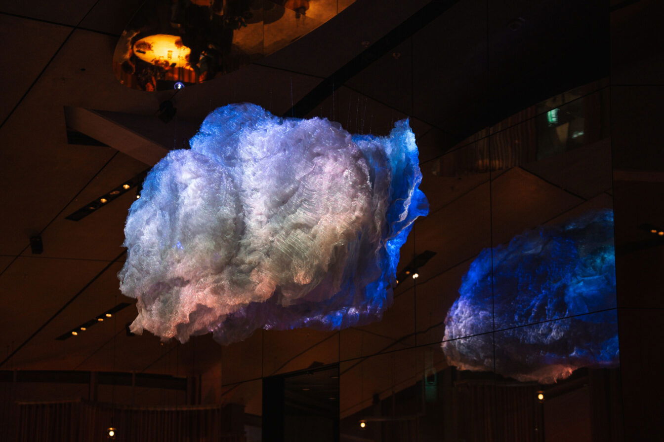 Beleuchtete Wolken-Kunstinstallation mit Spiegelung in modernem Innenraum von The Cloud