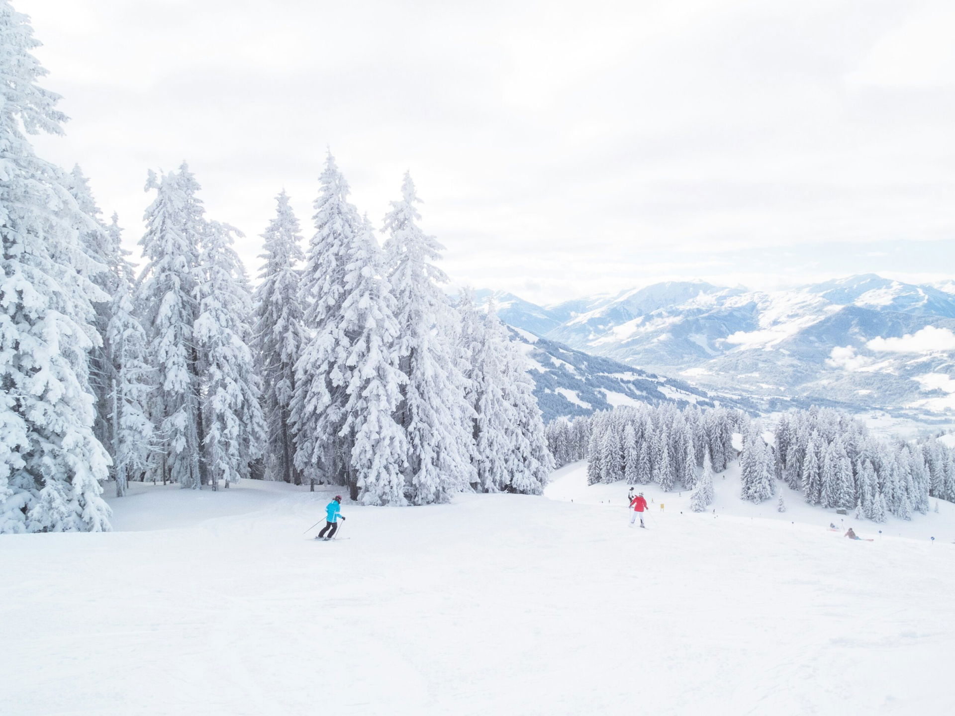 Skigebiet in Österreich mit Skifahrenden im Schnee (c) Luc van Loon | Unsplash